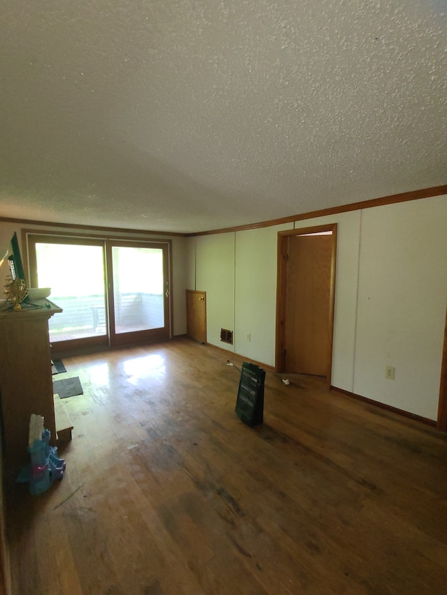 1814 Jasmine Ave, Flint, MI 48503 - unfurnished living room featuring a textured ceiling, wood finished floors, crown molding, and baseboards
