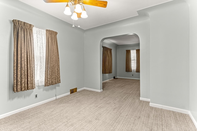 1281 Empire Ave, Lincoln Park, MI 48146 - unfurnished room with arched walkways, ceiling fan, carpet flooring, and healthy amount of natural light