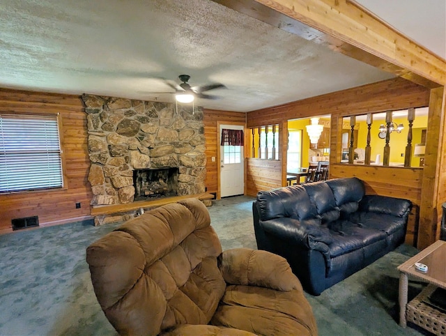 6452 Brian Circle Ln, Burton, MI 48509 - living room with wood walls, a textured ceiling, a stone fireplace, ceiling fan, and carpet floors