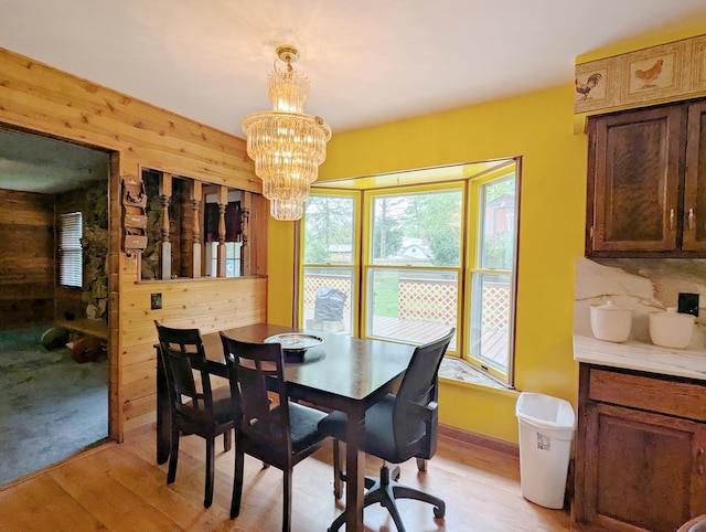 6452 Brian Circle Ln, Burton, MI 48509 - dining room with wood walls, light wood-style floors, and a chandelier
