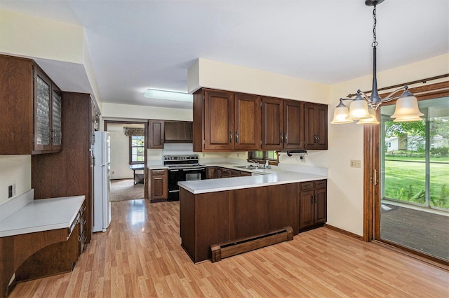 200 Brink St, Grant, MI 49327 - kitchen with black / electric stove, a baseboard radiator, freestanding refrigerator, light wood-style flooring, and a peninsula