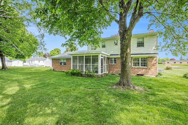 200 Brink St, Grant, MI 49327 - rear view of property featuring a sunroom, brick siding, a yard, and a chimney