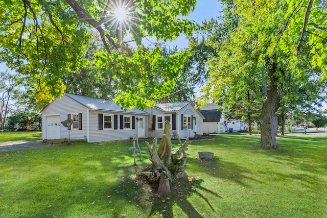 434 Walnut St, Howard City, MI 49329 - view of front of home featuring a chimney, a front yard, driveway, and metal roof