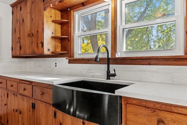 434 Walnut St, Howard City, MI 49329 - kitchen featuring a sink, decorative backsplash, light countertops, brown cabinetry, and open shelves