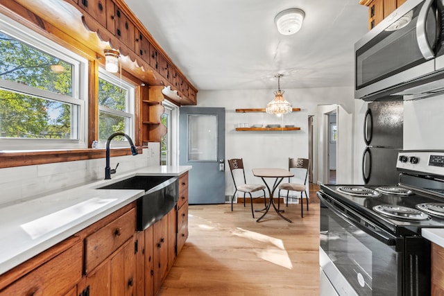 434 Walnut St, Howard City, MI 49329 - kitchen with stainless steel appliances, a sink, open shelves, and light countertops