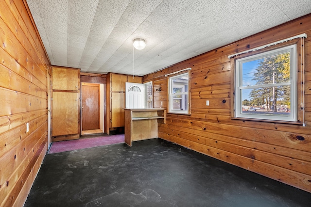 434 Walnut St, Howard City, MI 49329 - unfurnished bedroom featuring wooden walls and concrete floors