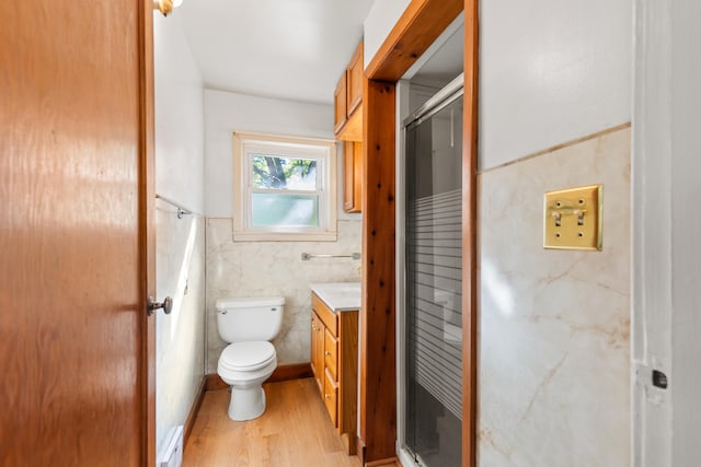 434 Walnut St, Howard City, MI 49329 - bathroom with a stall shower, wood finished floors, tile walls, toilet, and vanity