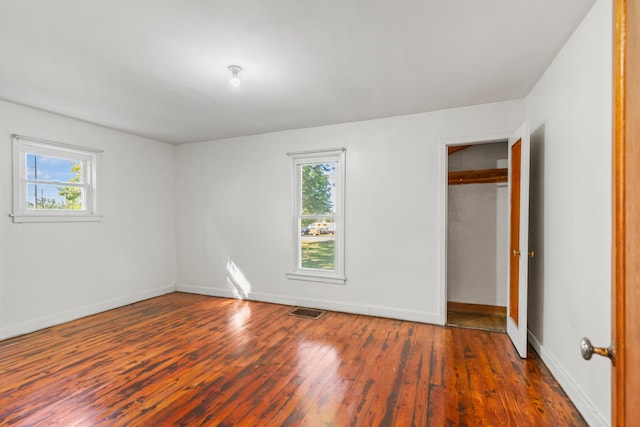 434 Walnut St, Howard City, MI 49329 - unfurnished bedroom with multiple windows, wood-type flooring, and baseboards