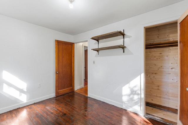 434 Walnut St, Howard City, MI 49329 - unfurnished bedroom featuring dark wood-type flooring and baseboards