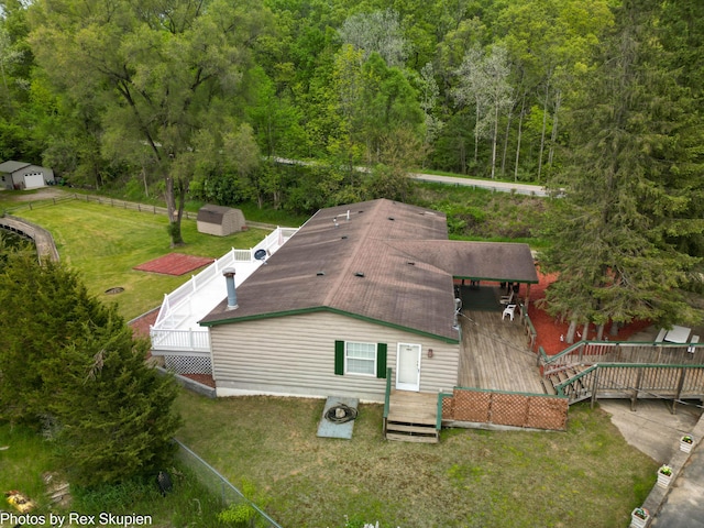 5705 Centerline Rd, Newaygo, MI 49337 - rear view of house featuring a deck, a forest view, and a lawn