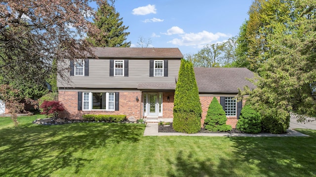 18080 Parke Ln, Grosse Ile, MI 48138 - view of front of home featuring brick siding, a front yard, and roof with shingles