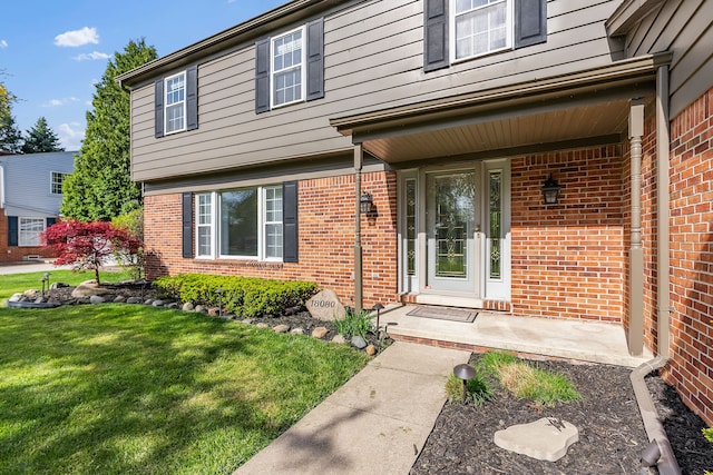 18080 Parke Ln, Grosse Ile, MI 48138 - property entrance with brick siding, a yard, and covered porch