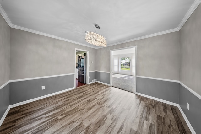 18080 Parke Ln, Grosse Ile, MI 48138 - spare room with wood finished floors, a chandelier, baseboards, and crown molding