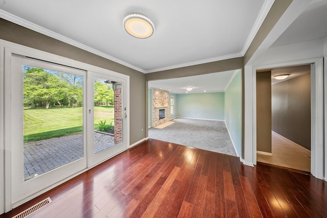 18080 Parke Ln, Grosse Ile, MI 48138 - unfurnished dining area featuring hardwood / wood-style flooring, baseboards, crown molding, and a fireplace
