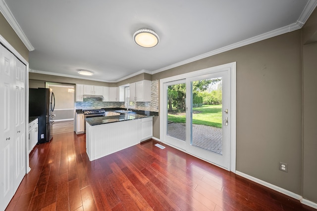 18080 Parke Ln, Grosse Ile, MI 48138 - kitchen with a peninsula, stainless steel appliances, dark wood-style flooring, a sink, and crown molding