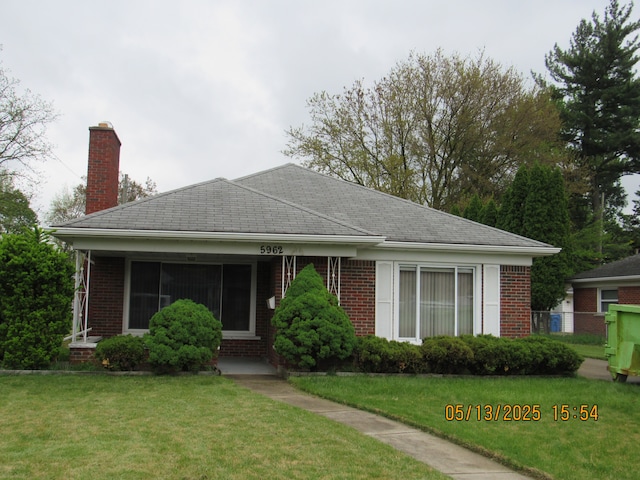 5962 Mcmillian Blvd, Dearborn Heights, MI 48127 - view of front of home featuring a chimney, brick siding, and a front yard
