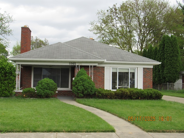 5962 Mcmillian Blvd, Dearborn Heights, MI 48127 - view of front of house with a front lawn, brick siding, and a chimney
