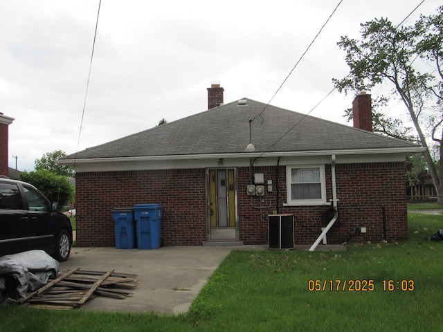 5962 Mcmillian Blvd, Dearborn Heights, MI 48127 - back of property with a chimney, brick siding, and a shingled roof