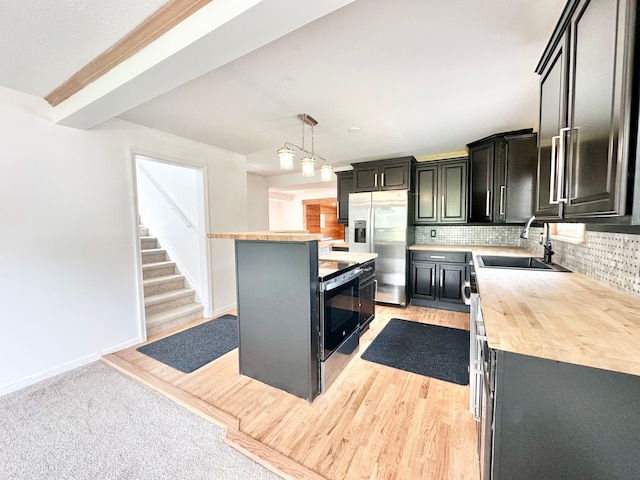 kitchen featuring a sink, stainless steel fridge with ice dispenser, dark cabinetry, backsplash, and butcher block countertops