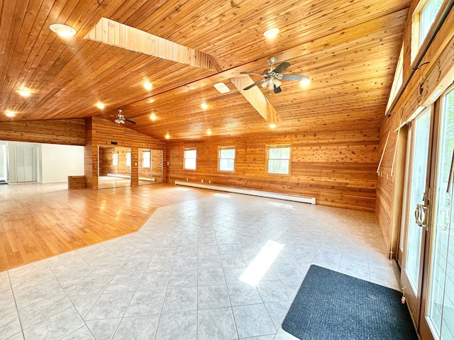 unfurnished living room with a ceiling fan, lofted ceiling, wood walls, wood ceiling, and plenty of natural light