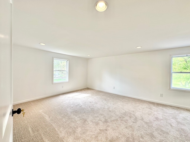 carpeted spare room featuring healthy amount of natural light, baseboards, and recessed lighting