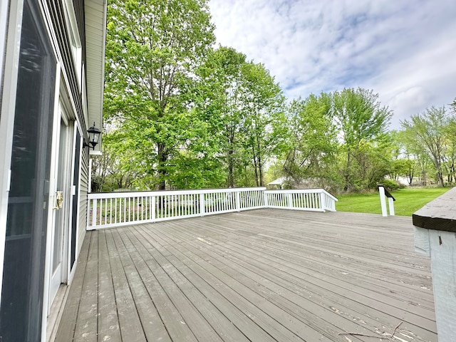 wooden terrace featuring view of scattered trees and a yard