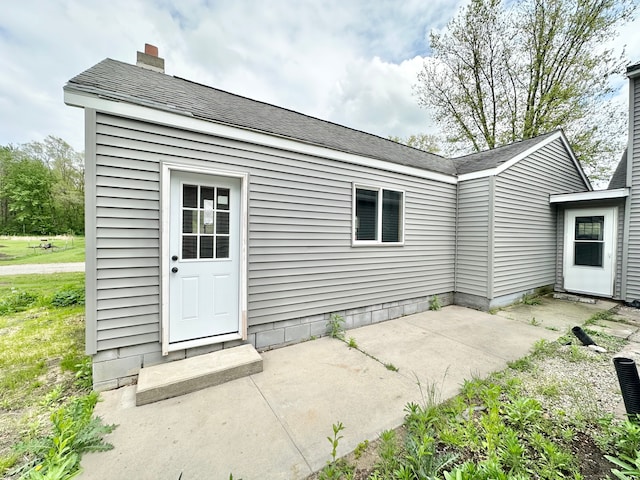 back of property featuring a patio area and a chimney