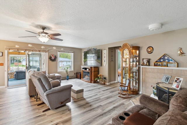 204 Crockett Dr, Quincy, MI 49082 - living area featuring a fireplace, a textured ceiling, light wood-type flooring, and a ceiling fan
