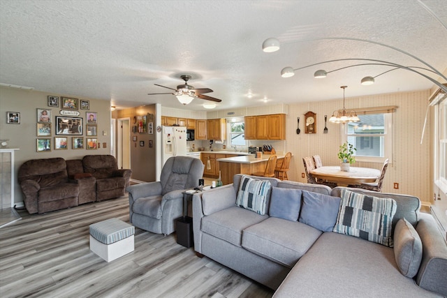 204 Crockett Dr, Quincy, MI 49082 - living room featuring light wood finished floors, a chandelier, a textured ceiling, and ceiling fan