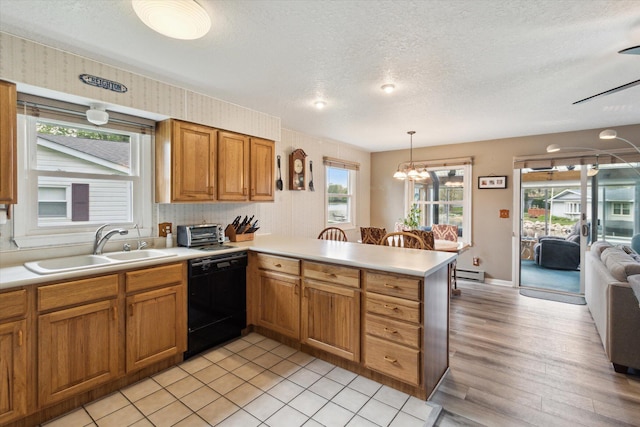 204 Crockett Dr, Quincy, MI 49082 - kitchen featuring dishwasher, a peninsula, light countertops, a textured ceiling, and brown cabinets