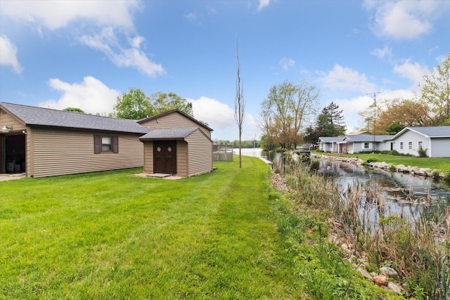 204 Crockett Dr, Quincy, MI 49082 - view of green lawn with a storage unit and a water view