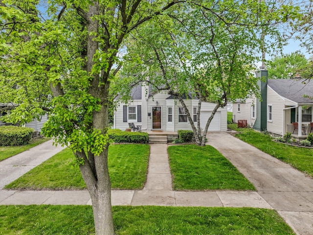 view of front facade featuring concrete driveway and a front lawn