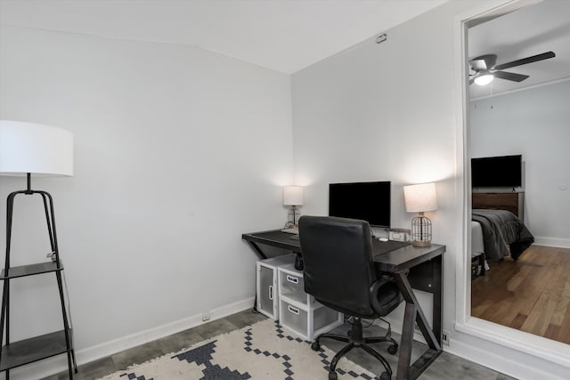 home office with wood finished floors, lofted ceiling, baseboards, and a ceiling fan