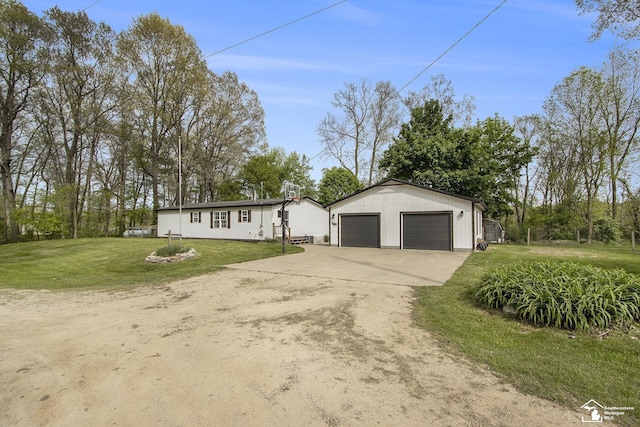 635 Pokey Dr, Hastings, MI 49058 - view of front facade featuring an outdoor structure, a front lawn, driveway, and a garage