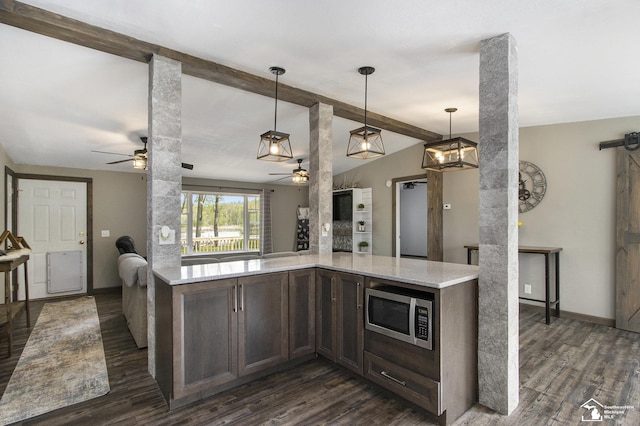 635 Pokey Dr, Hastings, MI 49058 - kitchen with ceiling fan, stainless steel microwave, dark wood-style flooring, hanging light fixtures, and light stone countertops