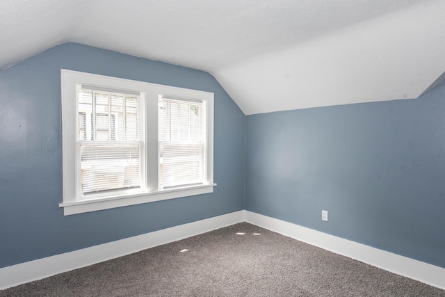 additional living space featuring vaulted ceiling, carpet, and baseboards