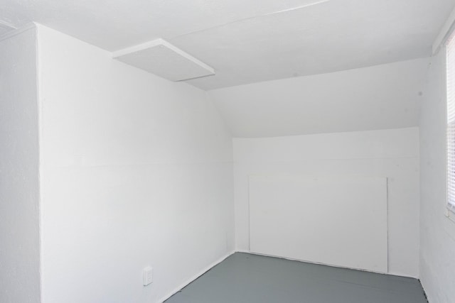 bonus room with lofted ceiling and concrete floors