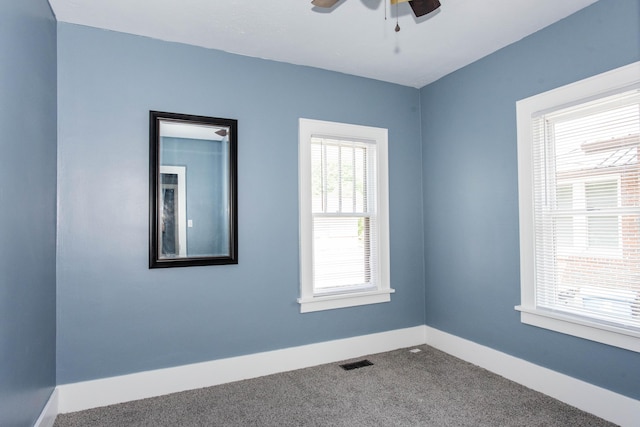 carpeted empty room with a ceiling fan and baseboards