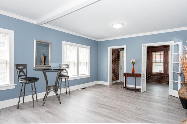 dining space with wood finished floors, baseboards, and ornamental molding