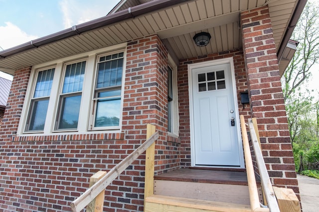 doorway to property featuring brick siding
