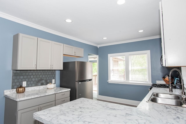 kitchen with freestanding refrigerator, a sink, a peninsula, light countertops, and recessed lighting