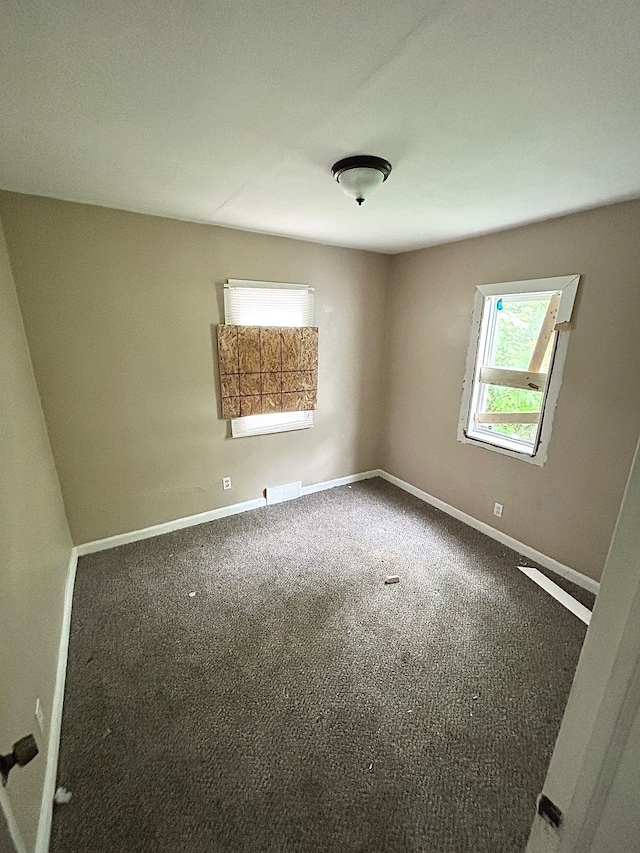 carpeted empty room featuring baseboards