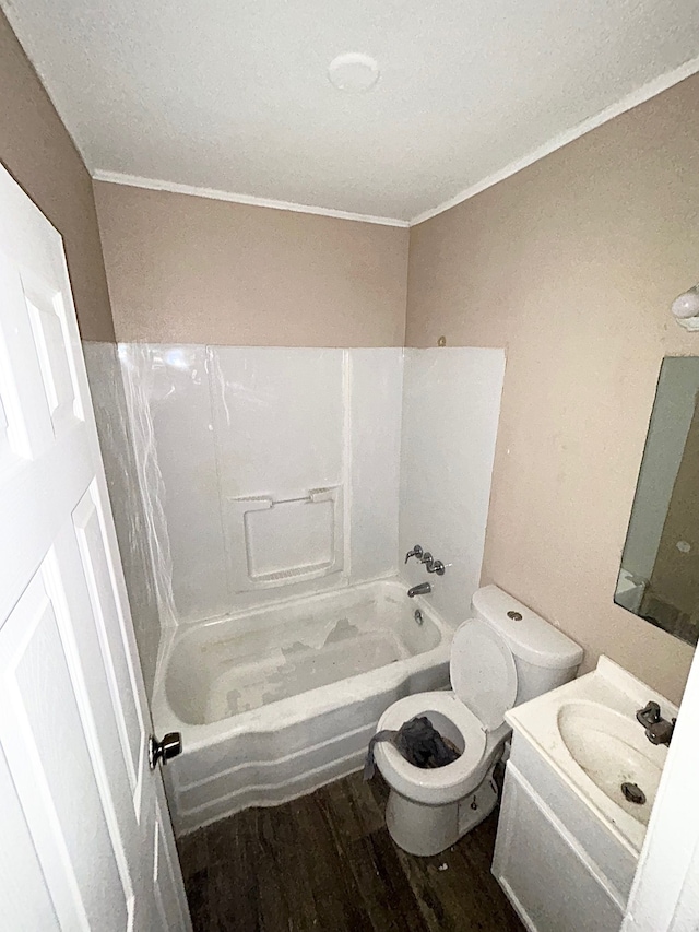 bathroom with ornamental molding, toilet, wood finished floors, bathing tub / shower combination, and vanity