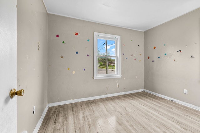 unfurnished room with light wood-type flooring and baseboards