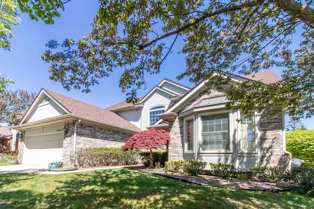 42852 Sandstone Dr, Novi, MI 48377 - view of front of home with brick siding, a garage, and a front lawn