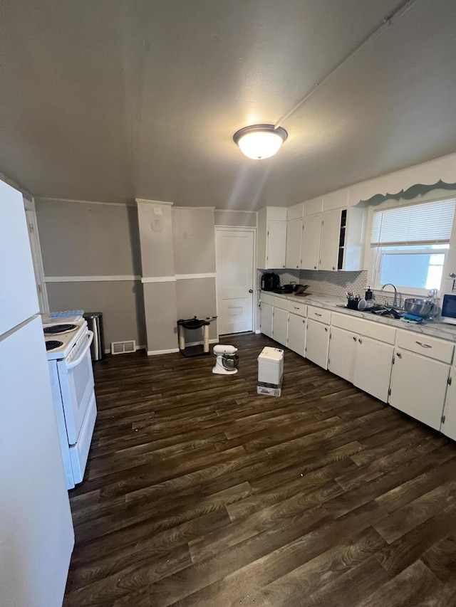 939 Baraga St NE, Grand Rapids, MI 49503 - kitchen with white appliances, white cabinets, dark wood-type flooring, and light countertops