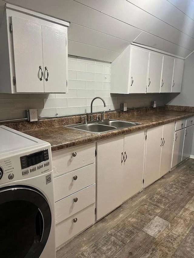 939 Baraga St NE, Grand Rapids, MI 49503 - kitchen featuring washer / clothes dryer, a sink, dark countertops, and white cabinetry