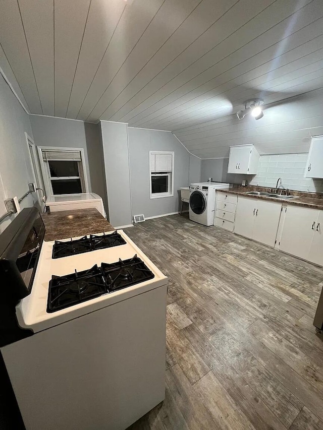 939 Baraga St NE, Grand Rapids, MI 49503 - kitchen featuring washer / dryer, white gas range, wood finished floors, white cabinets, and a sink