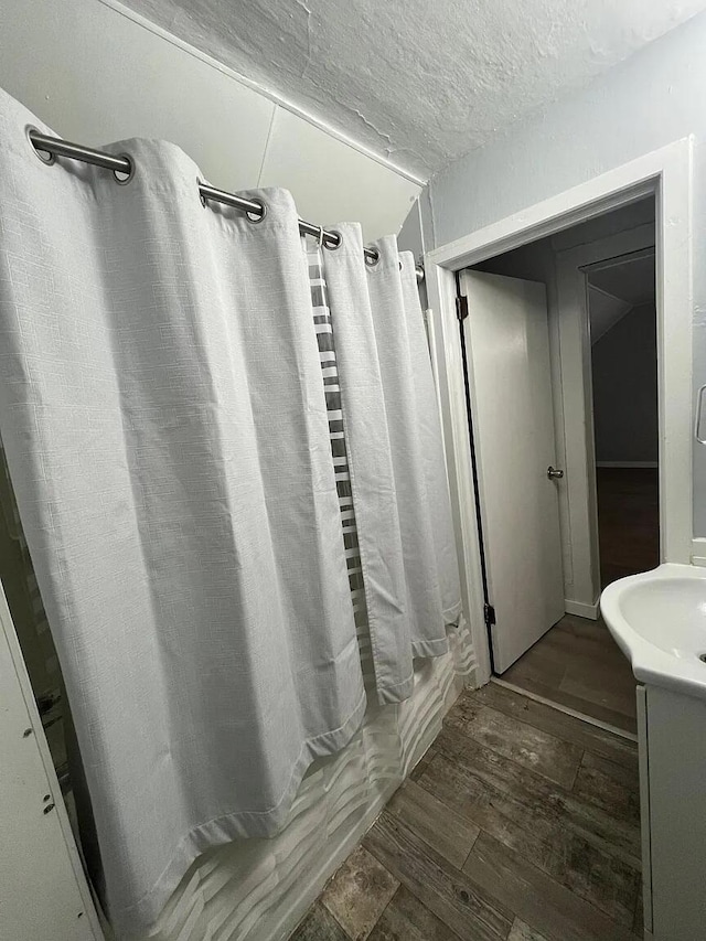 939 Baraga St NE, Grand Rapids, MI 49503 - bathroom featuring wood-type flooring, a textured ceiling, and a shower with shower curtain