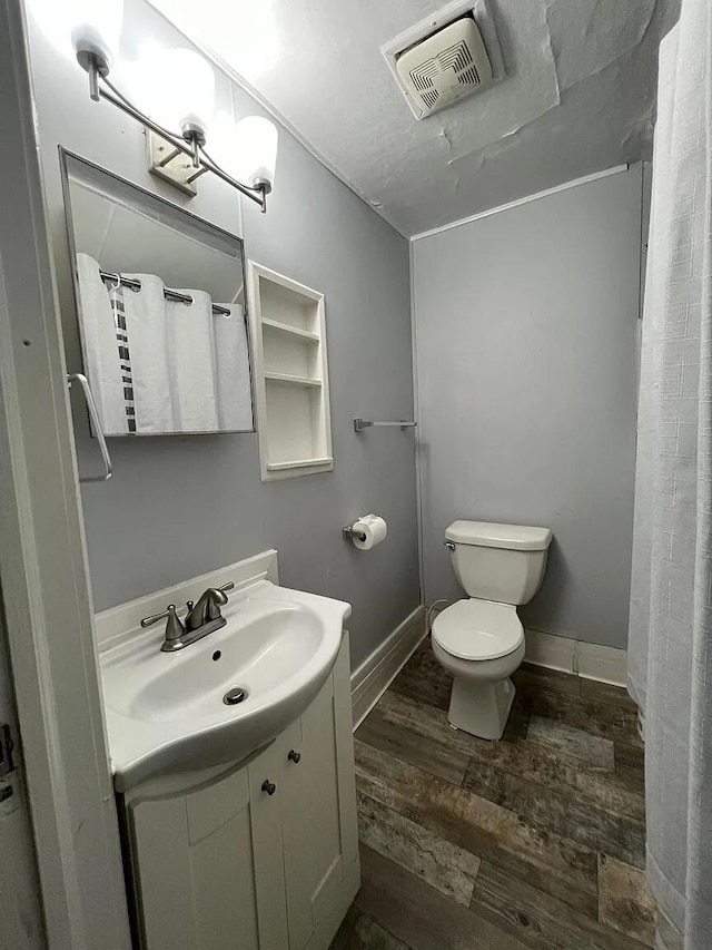 939 Baraga St NE, Grand Rapids, MI 49503 - full bath with wood finished floors, toilet, vanity, curtained shower, and baseboards